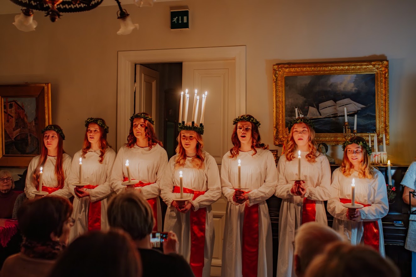 Lucia-kuoro laulaa kynttilät käsissään